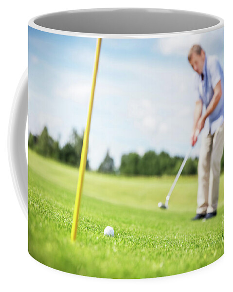 Man Coffee Mug featuring the photograph Senior man putting a ball in the hole. by Michal Bednarek