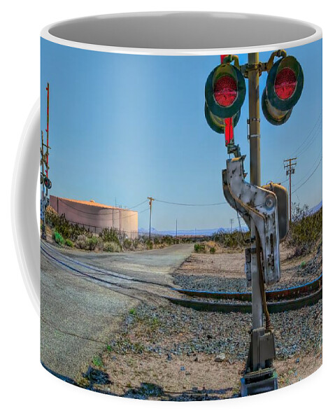 Railway Crossing; Railroad Crossing; Train Crossing; Union Pacific; Freight Train; Yellow; Blue; Green; Red; Water Storage; Train Tracks; Train Signal; Mojave Desert; Mohave Desert; Antelope Valley; Joe Lach; Coffee Mug featuring the photograph The Railway Crossing by Joe Lach