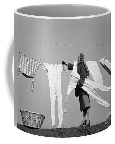 1940s Coffee Mug featuring the photograph Woman Removing Frozen Clothes by Debrocke/ClassicStock