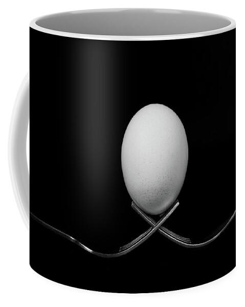 Egg Coffee Mug featuring the photograph White egg resting on two metal and shiny forks on a black backg by Michalakis Ppalis