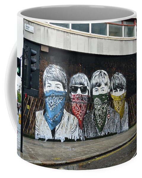 Bansky Coffee Mug featuring the photograph Yhe Beatles wearing face masks street mural in London by RicardMN Photography