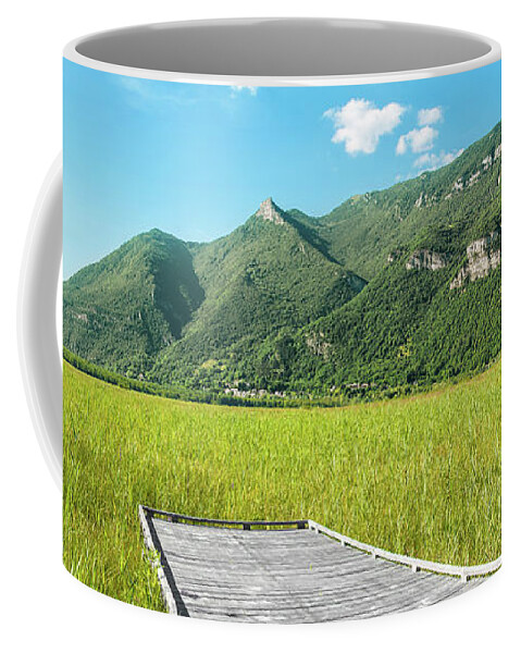 Mountain Coffee Mug featuring the photograph Beautiful mountain scenic with wooden footpath in field under sunlight by Gregory DUBUS