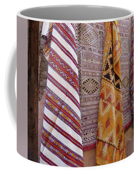 Bright Colored Coffee Mug featuring the photograph Bright colored patterns on throw rugs in the medina bazaar by Steve Estvanik