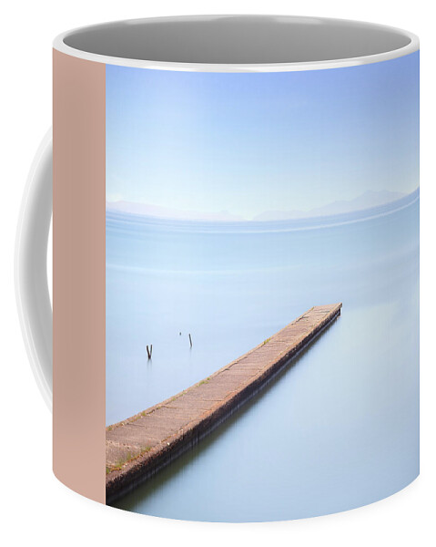 Concrete pier or jetty on a blue sea. Hills on background Coffee
