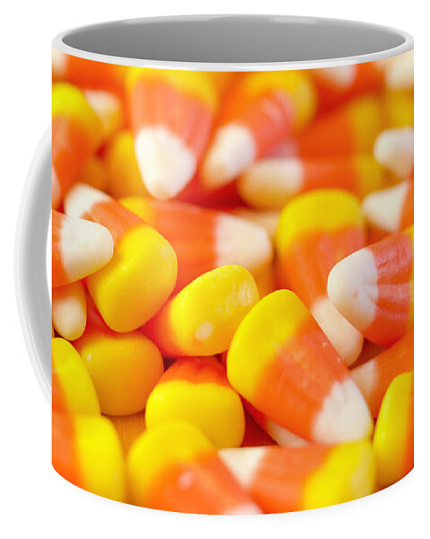 Halloween Coffee Mug featuring the photograph Macro closeup of Halloween traditional Candy Corn treats. by Milleflore Images
