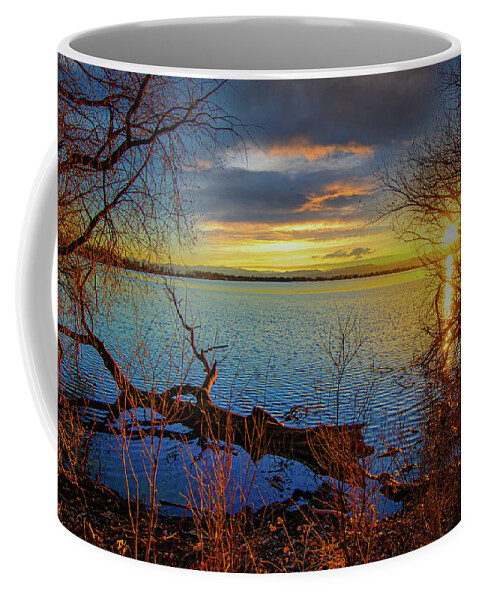 Autumn Coffee Mug featuring the photograph Sunset Over Barr Lake 2 Sunset over lake framed by bare tree branches, log floating nearby by Tom Potter