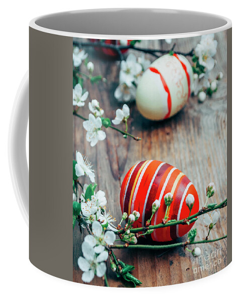Easter Coffee Mug featuring the photograph Closeup of colorful painted easter eggs and cherry blossom branc by Jelena Jovanovic