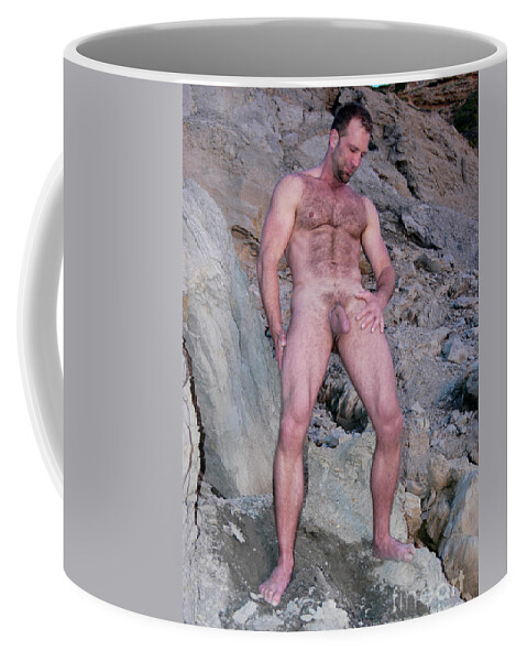 Nude Coffee Mug featuring the photograph Handsome and sexy hairy man stands in front of a rocky hillside. by Gunther Allen