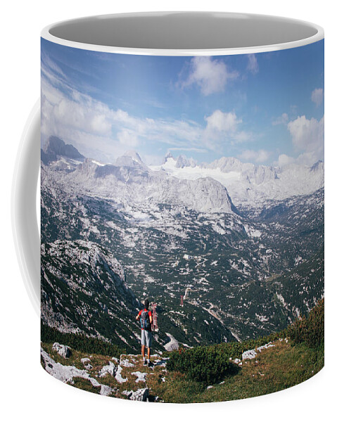 Sportive Coffee Mug featuring the photograph Man with a backpack looks at the Dachstein massif by Vaclav Sonnek