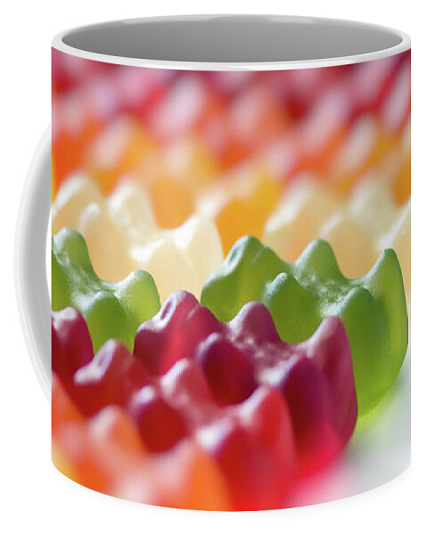 Candy Coffee Mug featuring the photograph Multi colored gummy bears candy in a row arrangement close-up by Gregory DUBUS