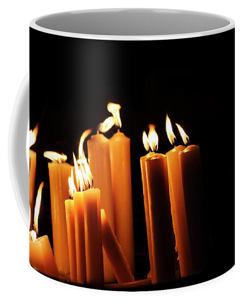 Candle Coffee Mug featuring the photograph Religious candles on black background. Yellow candlelight f by Jelena Jovanovic