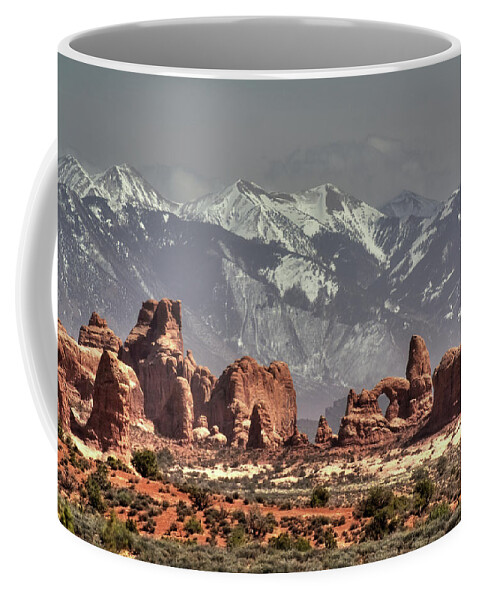 Arches Coffee Mug featuring the photograph Sandstone formations and Turret Arch vista in Arches National Park with La Sal mountains behind by Peter Herman