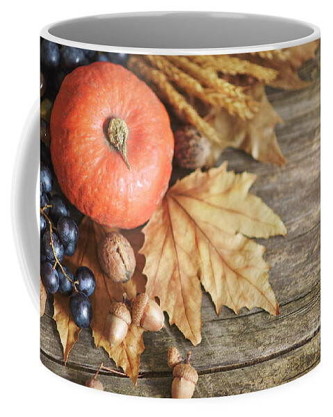 Thanksgiving Coffee Mug featuring the photograph Thanksgiving pumpkin with autumnal fruits on wooden table by Jelena Jovanovic