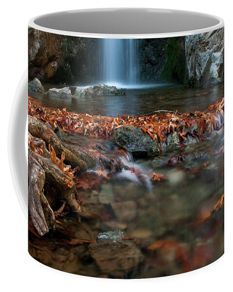 Troodos Coffee Mug featuring the photograph Waterfall and river flowing with maple leaves on the rocks on the river in Autumn by Michalakis Ppalis