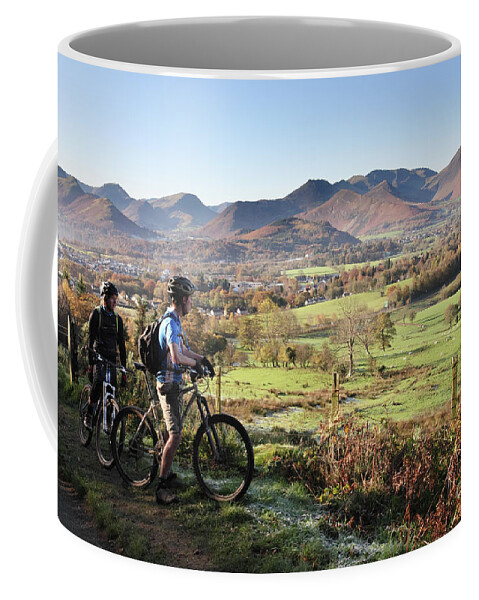 Young Coffee Mug featuring the photograph Young couple on bikes looking over Cumbrian fells, England, UK by Bryan Attewell