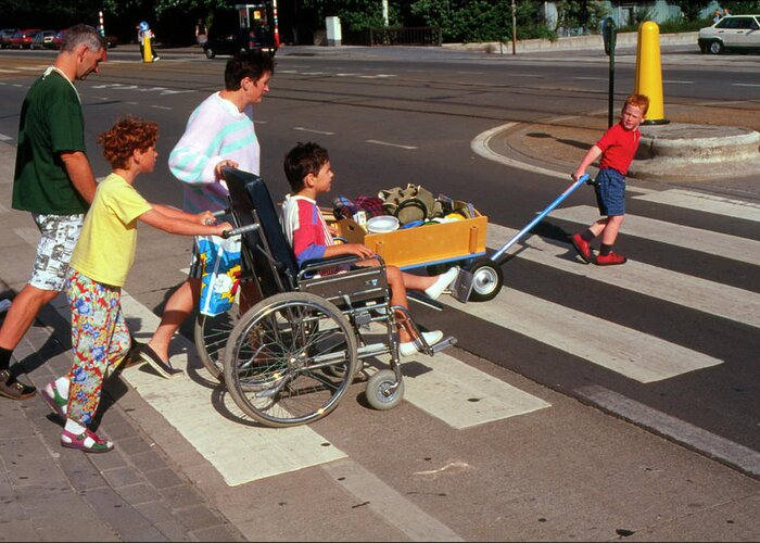 Wheelchair Greeting Card featuring the photograph Boy In Wheelchair Crossing Road With Family by Cc Studio/science Photo Library
