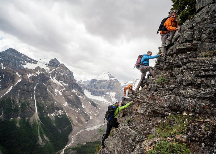 Scenics Greeting Card featuring the photograph Four Mountaineers Ascend Cliff Above by Ascent Xmedia