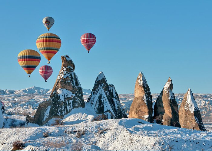 Wind Greeting Card featuring the photograph Hot Air Balloons Over Snow Covered Rock by Izzet Keribar