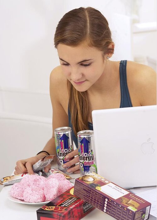 Energy Drink Greeting Card featuring the photograph Student eating sugary snacks by Science Photo Library