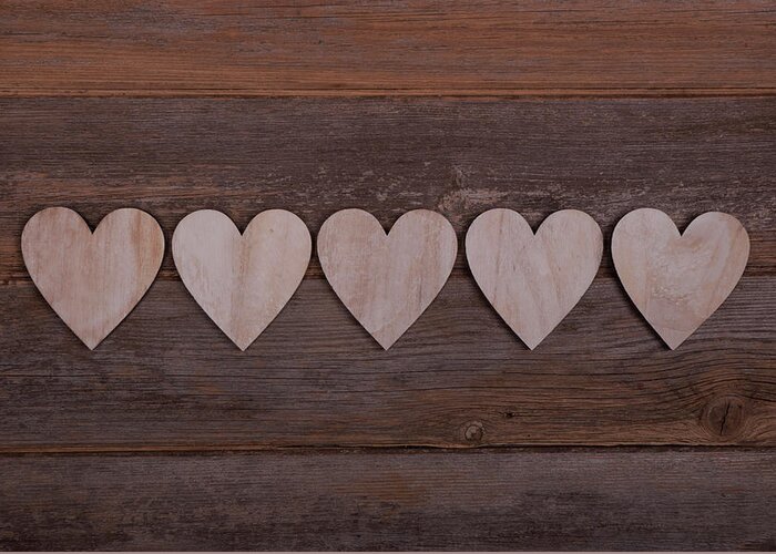 Five wooden hearts in a row on a wooden background Greeting Card by Anita  Van Den Broek