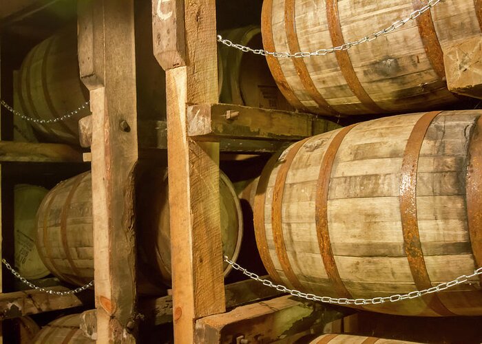 Aging Greeting Card featuring the photograph Oak bourbon barrels on rack in warehouse by Karen Foley