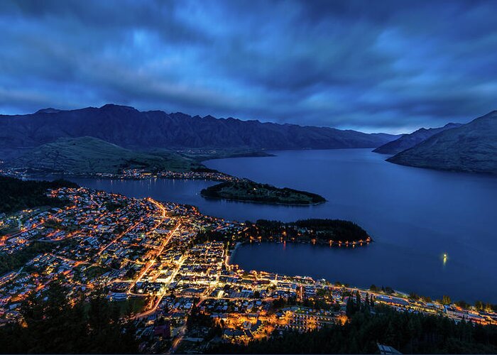 New Zealand; Water; Lee Filter; Big Stopper; Serenity; Tranquility; Long Exposure; Tungsten; Blue; Slow Shutter; Photo; Queenstown; City; Cobalt; Kiwi; Lights;town; Mountains; Lake; Clouds; Urban; Land; Peaceful; South Island; Golden Hour; Blue Hour; Aotearoa; Famous; Landmark; Malaysian Photographer; Travel Greeting Card featuring the photograph Queenstown Lights Up by Kumar Annamalai