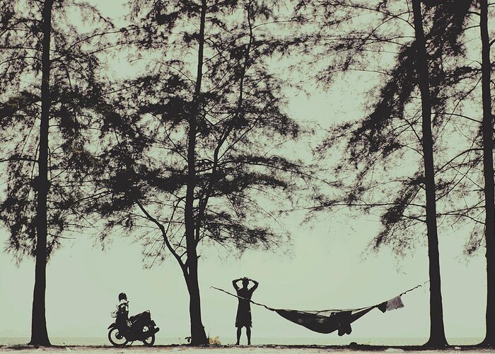 Adventure Greeting Card featuring the photograph Silhouette of a young men with crossed hands above his head camping hammocking in the nature by Srdjan Kirtic