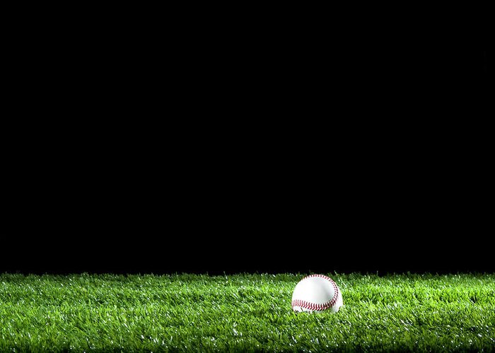 Softball Greeting Card featuring the photograph Baseball In The Grass At Night by Courtneyk