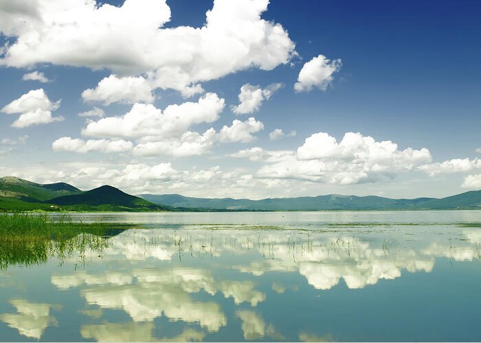 Water's Edge Greeting Card featuring the photograph Cumulus Clouds And Reflection In The by Aleksandargeorgiev