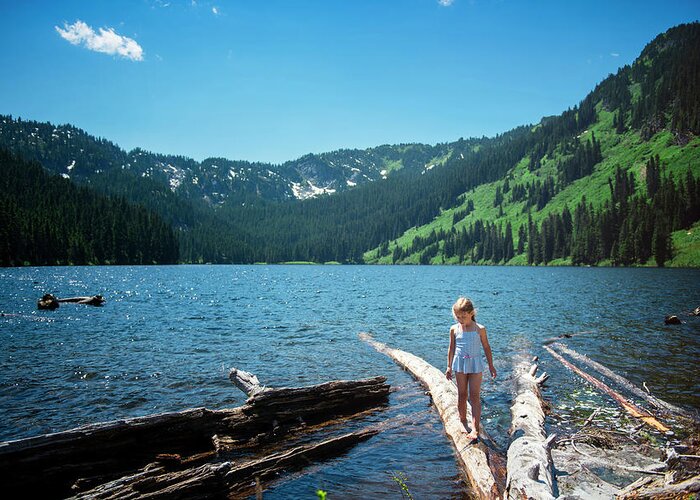 Girl Greeting Card featuring the photograph Girl Walking On Log In Lake Against Blue Sky At Forest by Cavan Images