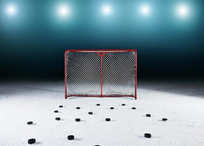 Goal Greeting Card featuring the photograph Ice Hockey Goal Surrounded By Pucks by Robert Decelis Ltd