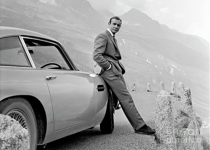 James Bond Greeting Card featuring the photograph James Bond Coolly Leaning on His Aston Martin by Doc Braham