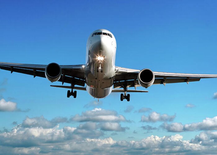 Freight Transportation Greeting Card featuring the photograph Jet Airplane Landing In Cloudy Sky by Sharply done