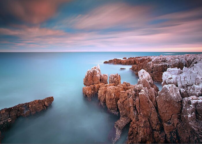 Scenics Greeting Card featuring the photograph Rocks In Sea At Sunset by Eric Rousset