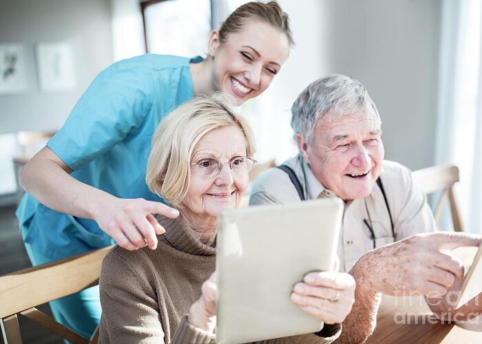 Indoors Greeting Card featuring the photograph Senior Couple Using Tablets by Science Photo Library