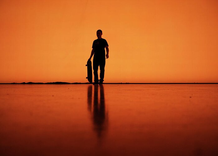Orange Color Greeting Card featuring the photograph Silhouette Of Man With Skateboard by Mgs