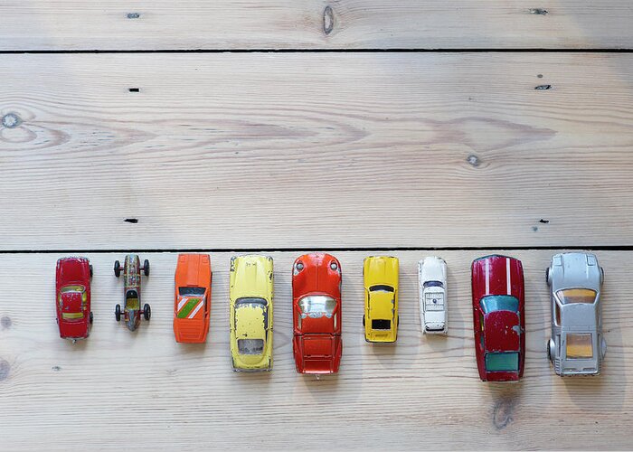 In A Row Greeting Card featuring the photograph Toy Cars Lined Up In A Row On Floor by Dougal Waters