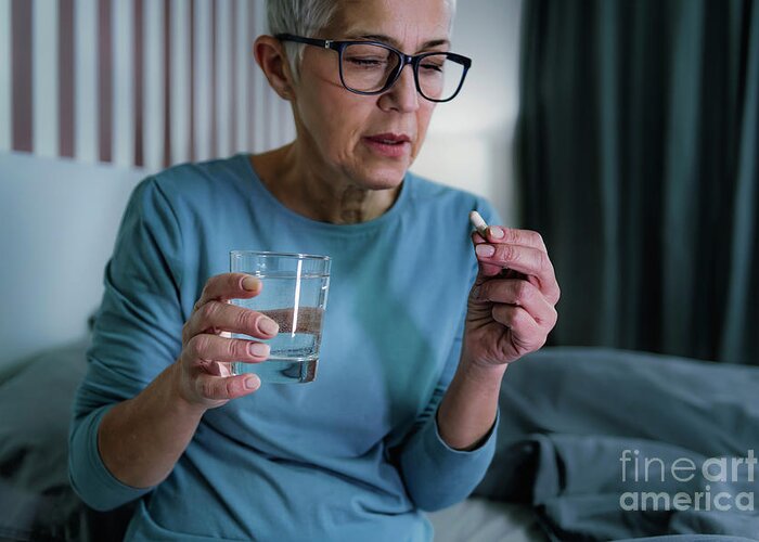 Sleepless Greeting Card featuring the photograph Woman Taking Melatonin Pills by Microgen Images/science Photo Library