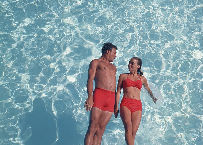 Young Men Greeting Card featuring the photograph Young Couple Jumping In Swimming Pool by Tom Kelley Archive