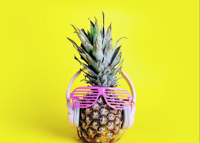 Pineapple Greeting Card featuring the photograph Fashionable trendy pineapple fruit with headphones and sun glas #1 by Jelena Jovanovic