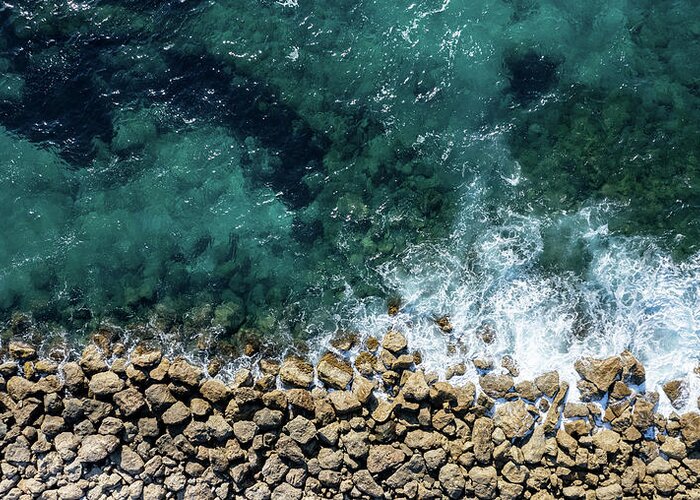 Seascape Greeting Card featuring the photograph Aerial view from flying drone of crystal blue ocean water and sea wall. by Michalakis Ppalis