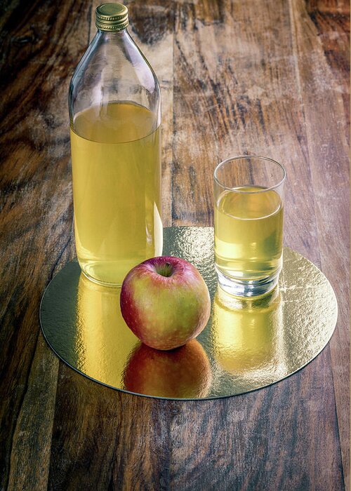 Drinking Glass Greeting Card featuring the photograph Fresh apple juice and red apple on a rustic wooden table by Benoit Bruchez