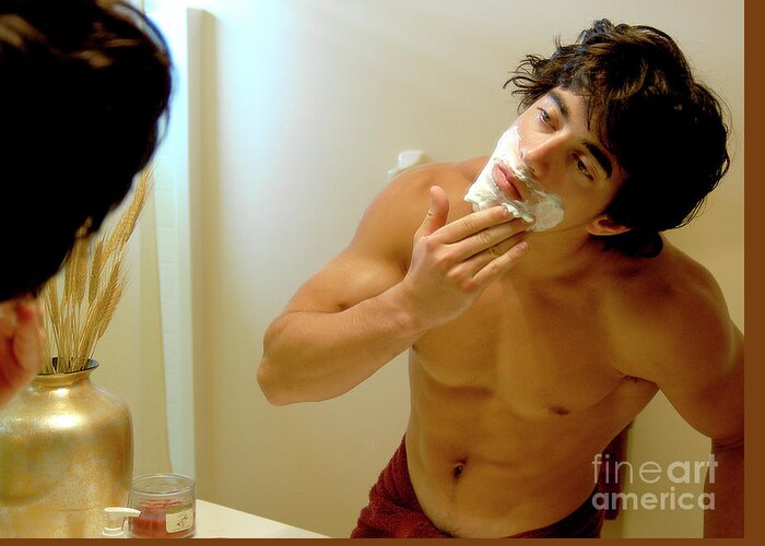 Shave Greeting Card featuring the photograph Handsome young man is putting on shaving cream. by Gunther Allen