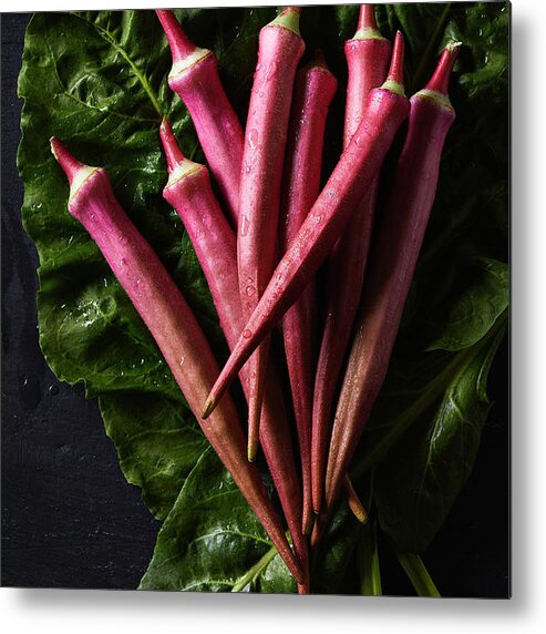 Red Okra Metal Print featuring the photograph Wet red okra on bed of chard by Cuisine at Home