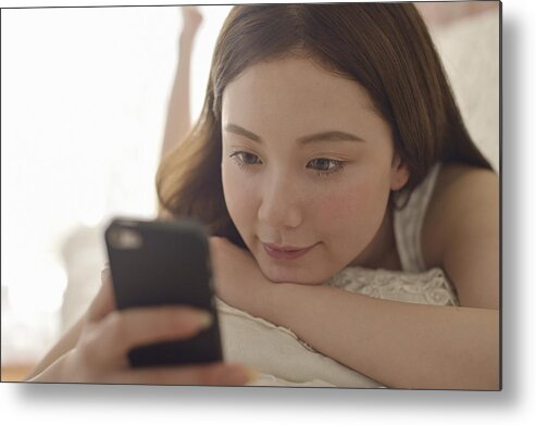 People Metal Print featuring the photograph Women using Smartphone on the sofa. #2 by Yagi Studio