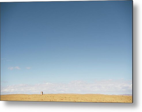 Barren Metal Print featuring the photograph A Water Tower Sits Alone In Grassland by Blake Gordon