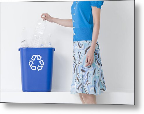Environmental Conservation Metal Print featuring the photograph A woman putting a bottle in a recycling bin by Image Source