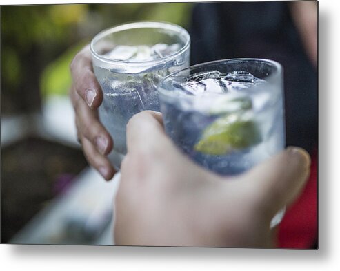 Tropical Tree Metal Print featuring the photograph Celebration concept with hand close-up of a couple celebrating the beginning of their vacations with each a gin & tonic. by Instants