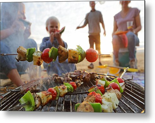 Mid Adult Women Metal Print featuring the photograph Family having BBQ on beach by Peter Cade