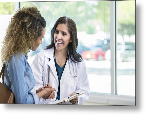 Working Metal Print featuring the photograph Female doctor discusses something with young mixed race patient by Asiseeit